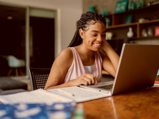 A french female student sitting in front of her laptop - taking single courses online at Academy.