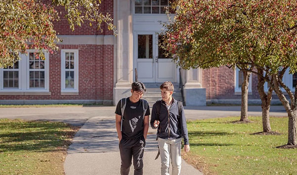 Two boys walking in front of Thornton Academy school building.