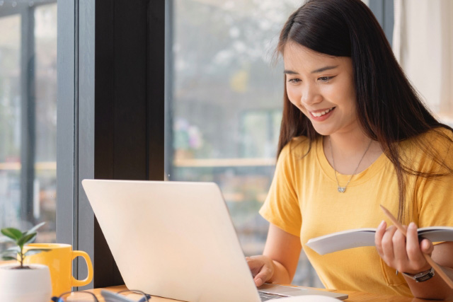 A female asian high school student is studying online.