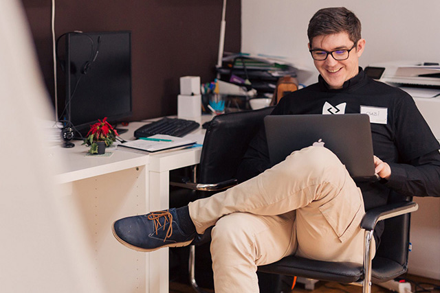 Male student sitting with his computer in his lap discussing academic counseling.