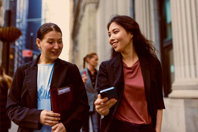Partner with Educatius Academy - Two business women walking in city center.